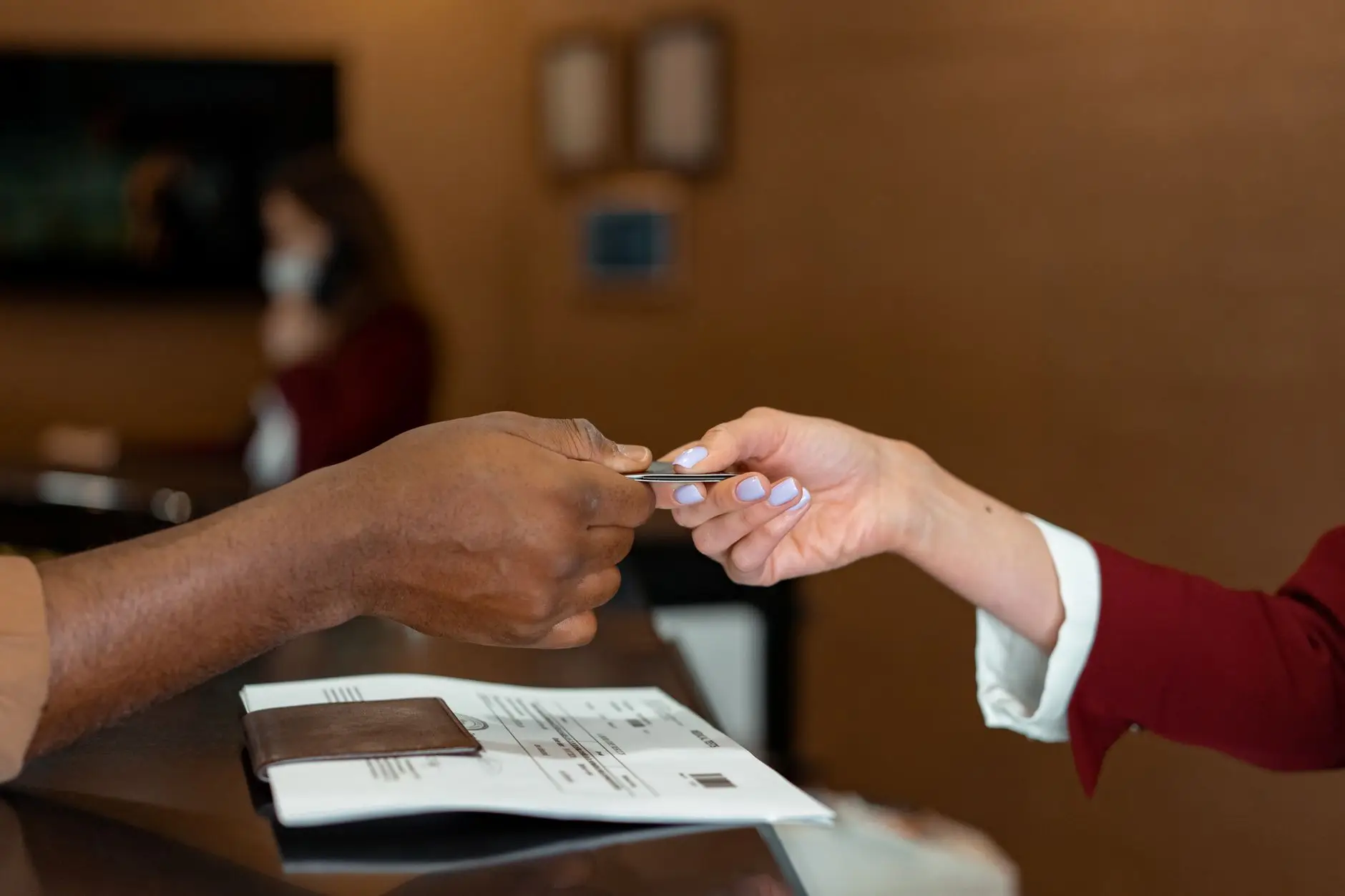 Four key reasons why Bonvoy points are better than Marriott Free Night Certificates - traveler using credit card hotel lobby